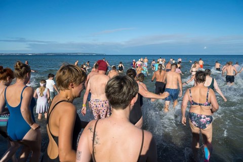 Swimmers run into water to bathe, tourist attraction Binzer Abbaden, Binz, seaside resort, Rügen