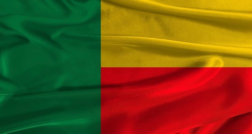 Flag of Benin with fabric textured background. Close up of National flag of Benin with realistic