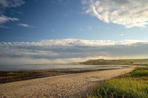 Idyllic morning atmosphere on a coast with beach, grass and wide sky on the beach of Kiberg, Troms,