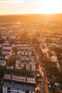 Residential areas in a city under a warm sunset sky, with glowing streets, Calw, Black Forest,