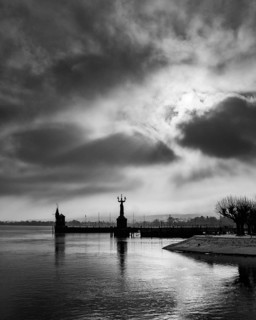 View across Lake Constance to the port of Constance with harbor entrance and the Imperia statue, on