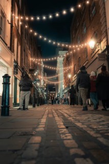 Old alley with lights and people in a warm and inviting atmosphere, London, England, United Kingdom