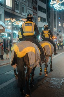 Mounted police at night on a street with festive lights, London, England, Great Britain