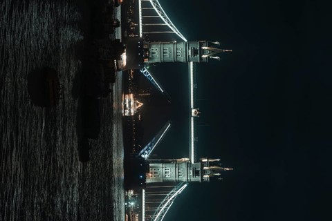 Illuminated Tower Bridge stretches across the river at night, London, England, Great Britain