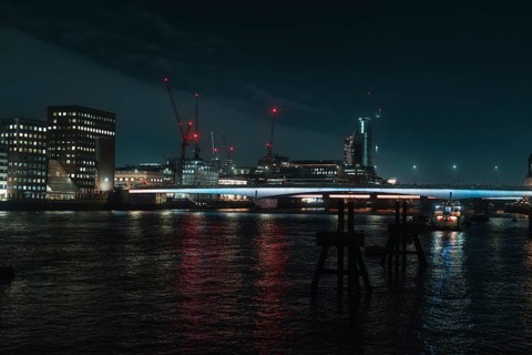 River landscape with night lighting and visible cranes, London, England, Great Britain