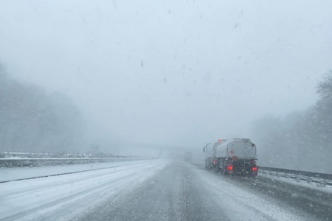 View through the windshield of a passenger car in poor visibility Driving through light snowblowing