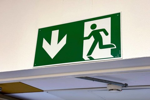 Sign with escape route emergency exit pictogram and down arrow, Germany
