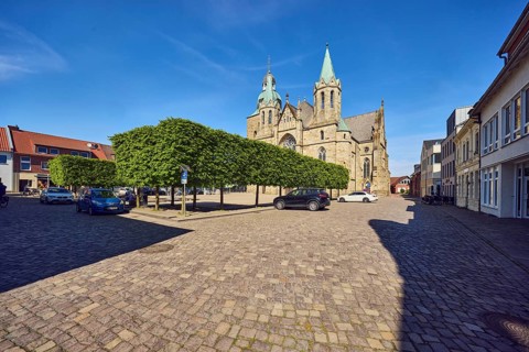 St. Victor church, general architecture, square made of paving stones, parking boxes with cars,