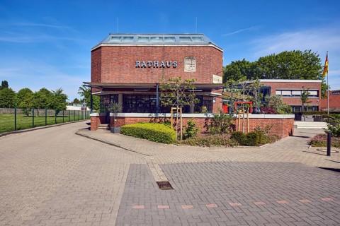 Town hall, brick building, flat roof, modern architecture, flower bed, hedge, street made of