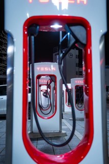Tesla charging stations at night with red lighting and modern optics, Tesla Supercharger,