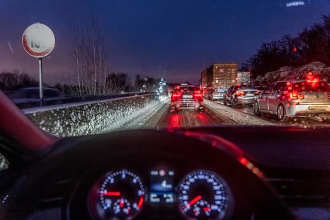 Driving in winter, in snow, motorway, rear lights, brake lights, speedometer, cockpit