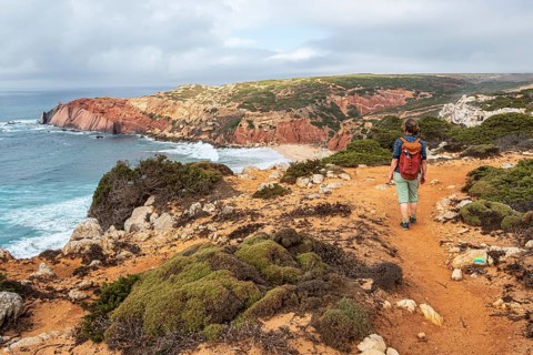 Hiking woman, view over cliff, Fishermens Trail, Rosa Vicentina, western Algarve just north of cape