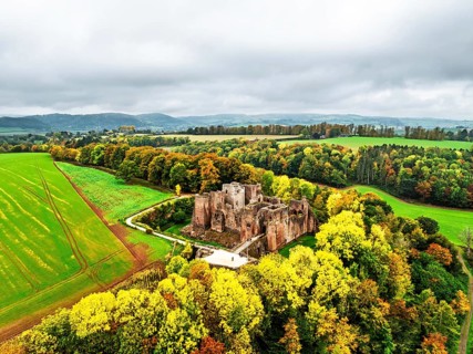 Autumn Colours over ruins of Goodrich Castle and River Wye from a drone, Goodrich, Herefordshire,