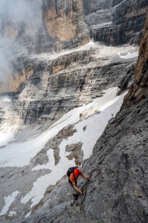 Mountaineer climbs a ladder in steep rocky terrain, Via Ferrata Oliva Detassis via ferrata, Brenta