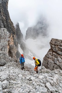 Two mountaineers in rocky, cloudy mountain landscape at Bochetta Bassa del Massodi, Brenta
