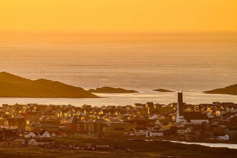 View of the city of Vardø from Mount Domen, sea at sunset with golden sky and calm atmosphere,