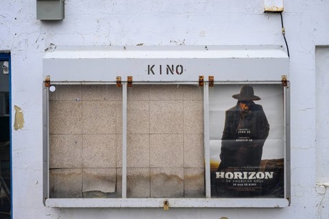 Cinema poster on a white painted wall with some peeling paint, Berlevåg, Finnmark, Norway