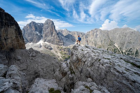 Mountaineers on a rock in front of picturesque mountain landscape with rocky peaks, Via Ferrata