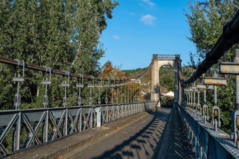 Suspension bridge of Coudes village on river Allier. Puy de Dome. Auvergne Rhone Alpes. France
