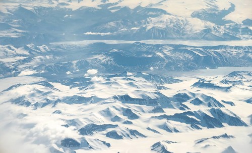 Icy, snowy arctic mountain landscape with glaciers and fjords, aerial view, Greenland, Arctic