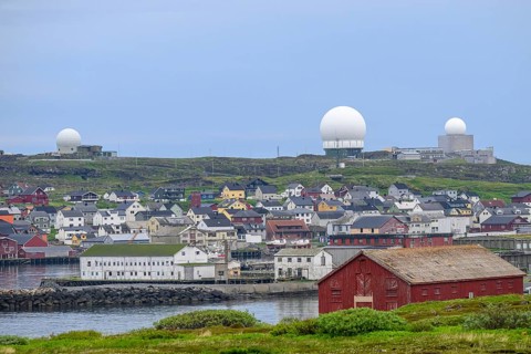 View of the port city of Vardø with large NATO radar systems on a hill in the background, Vardö,