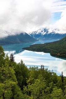 View of snowy mountains in spring and turquoise Kenai Lake with reflection, Slaughter Ridge Trail,