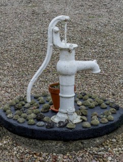 Classic hand pump for water as a decoration in a courtyard in Ystad municipality, Skåne county,