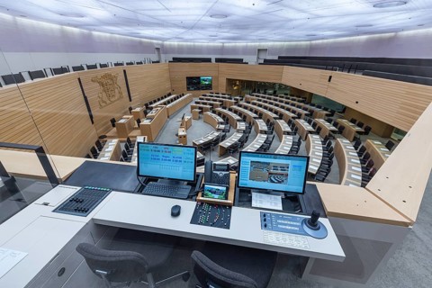 Plenary hall deserted with the seats of deputies and the government bank. Behind it is the