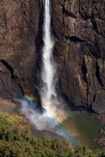 Daytime top view at Wallaman Falls with rainbow in mist over cascading water, Queensland, Australia