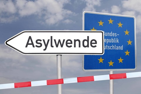 (Photo montage) Directional arrow with the inscription ASYLUM TURNDE in front of a border sign of