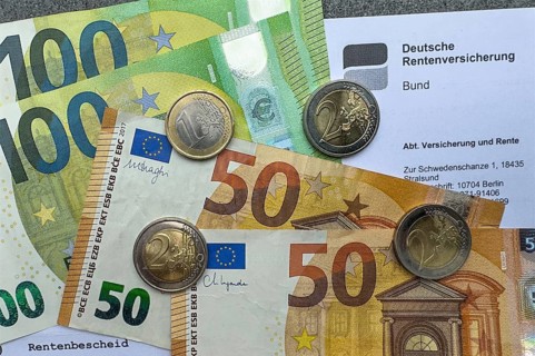 Symbolic photo document pension certificate from Deutsche Rentenversicherung on it cash banknotes
