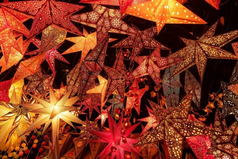 December 22, 2025, many glowing Christmas stars hanging at a market stall near St. Paul's Church,