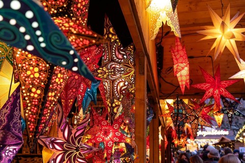December 22, 2025, many glowing Christmas stars hanging at a marke t stall near St. Paul's Church,