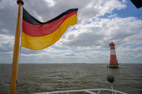 German flag and Angaster lighthouse in Jade Bay taken from an excursion ship, Jade Bay, Lower