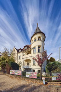 Historic residential buildings, turrets, balcony, façade with windows, trees with autumn leaves,