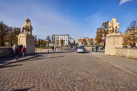 Entrance portal, horse sculpture, car bridge and footbridge, cobblestones, barrier bollard,