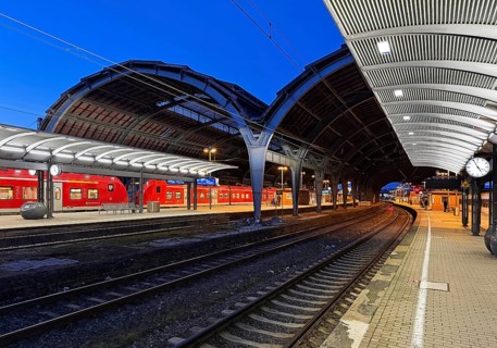 Empty platform with the two-nave platform hall and regional express in the evening, central railway