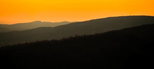 Silhouettes of mountains at sunset with orange sky, Vadsö, Finnmark, Norway