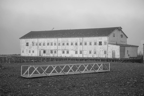 Elongated façade of an old port building in a foggy coastal atmosphere, Vardø, Finnmark, Norway