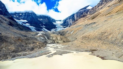 Sun shining over the athabasca glacier in jasper national park, alberta, canada, with meltwater
