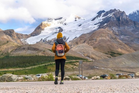 Female tourist walking towards athabasca glacier in jasper national park, alberta, canada, admiring