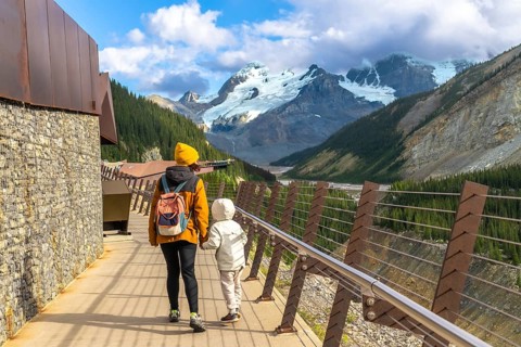 Mother and child walking on the glacier skywalk, enjoying the breathtaking view of the athabasca