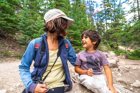 Mother and son taking a break during a hike in mistaya canyon, banff national park, enjoying a