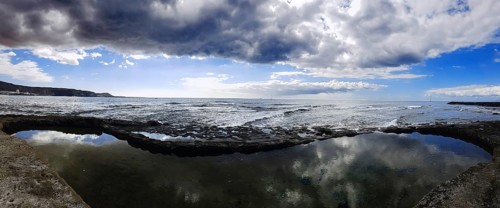 Broad view of a coastal landscape with cloud reflection in the water, Los Cristianos, Tenerife