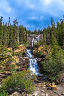 Water cascading over rocky cliffs at tangle creek falls in jasper national park showcases nature's
