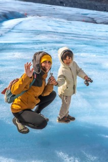 Mother and her son are enjoying their time on the athabasca glacier, waving happily amidst the