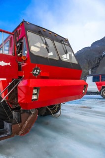 Red ice explorer bus parked on the athabasca glacier, offering breathtaking views of the canadian