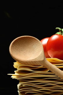 Cooking spoon and lasagna leaves with tomatoes
