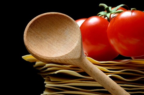 Cooking spoon and lasagna leaves with tomatoes