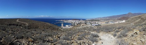 Panoramic view of the tourist town of Los Cristianos with the sea in the foreground and mountains